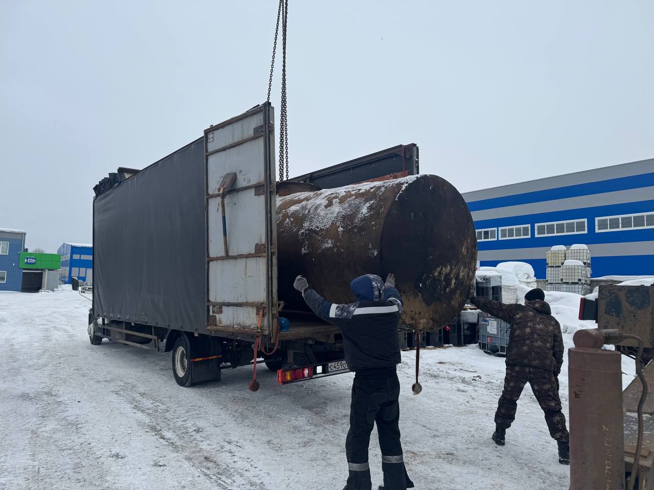 Погрузка бочки в машину перед отправкой